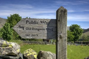 Wooden sign indicating public way and direction to Old Dungeon Ghyll